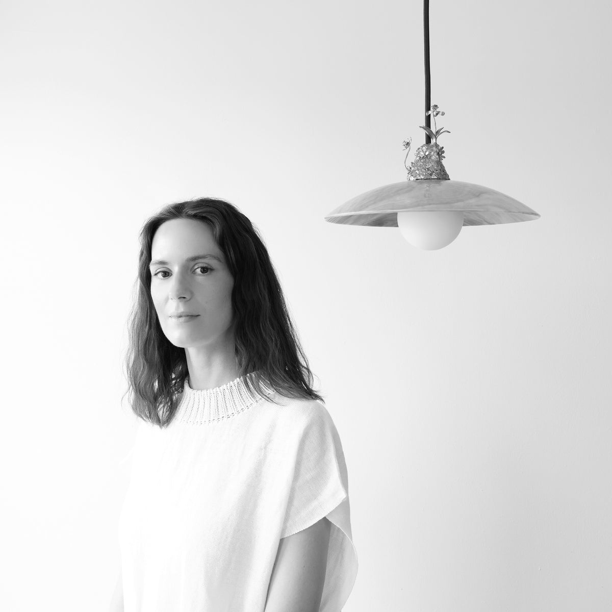 Julia Blume seated in her studio surrounded by sculptural work