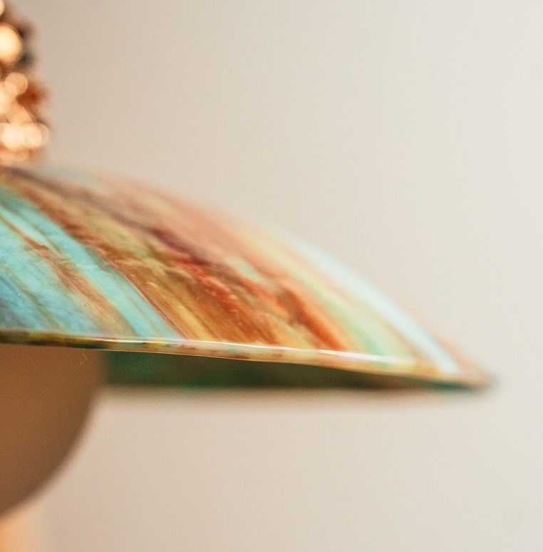Close view of a Verrité glass pendant in warm light