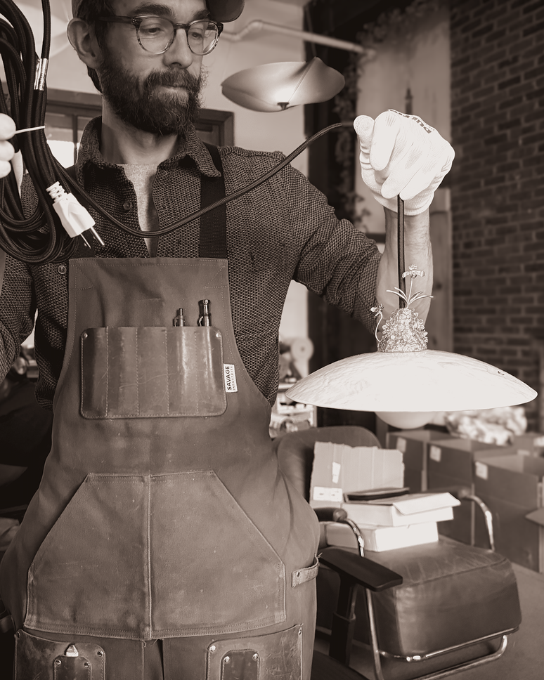 A fabricator working beside a studio window