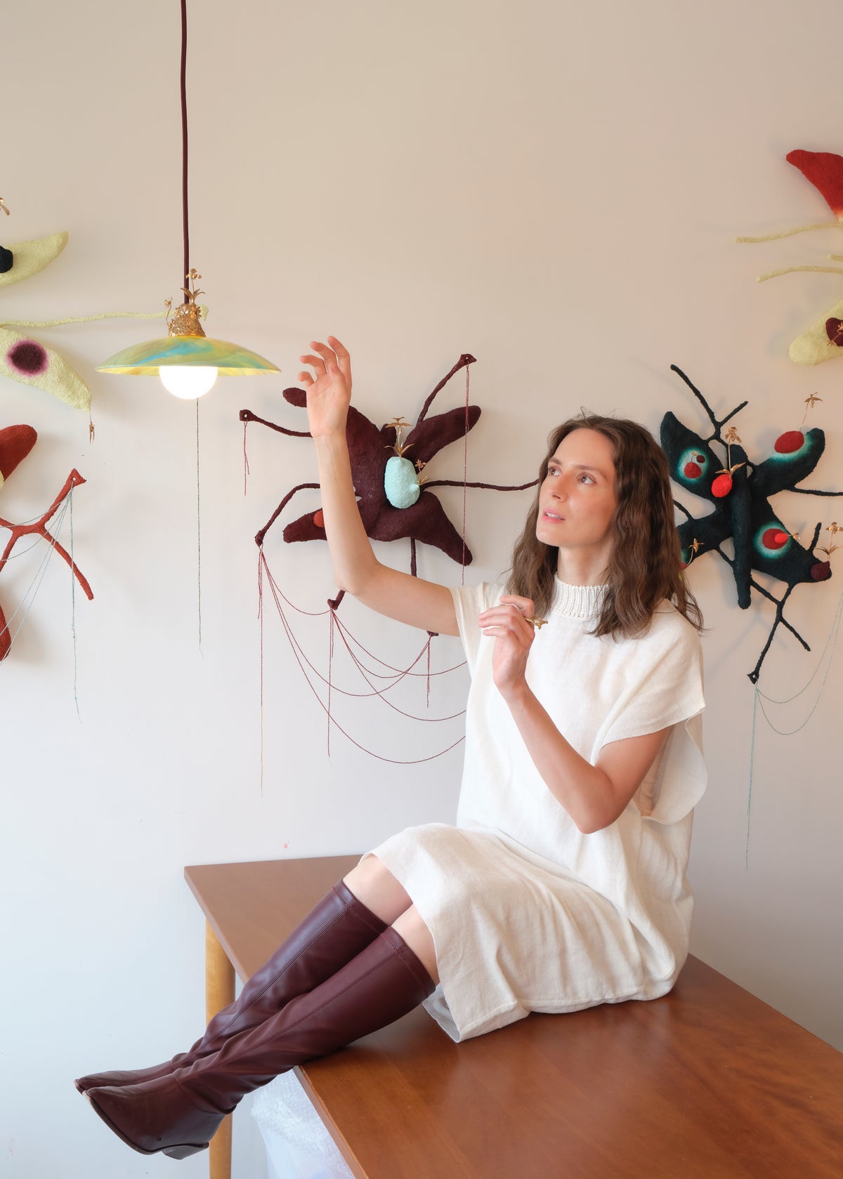 Julia Blume seated in her studio beneath the Silva pendant